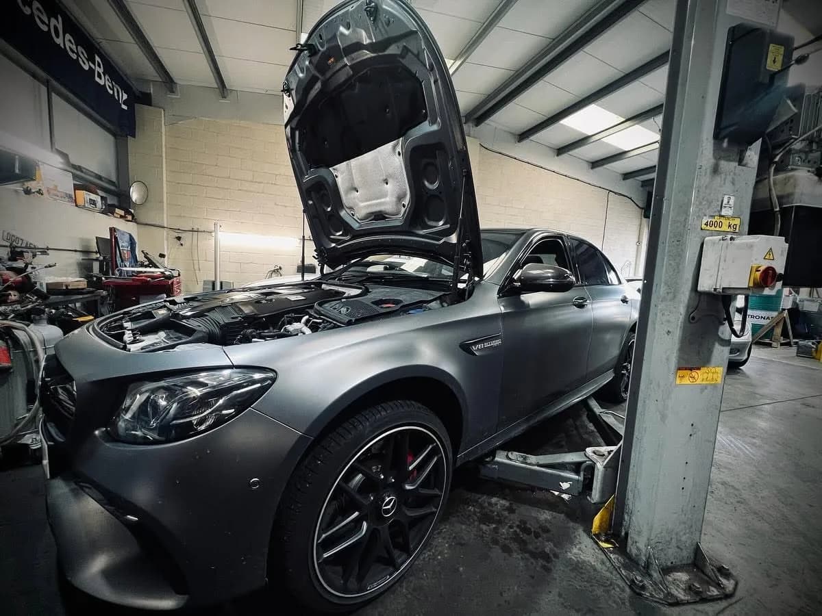 Mercedes-Benz on ramp with bonnet open for diagnostics at Benza Autos
