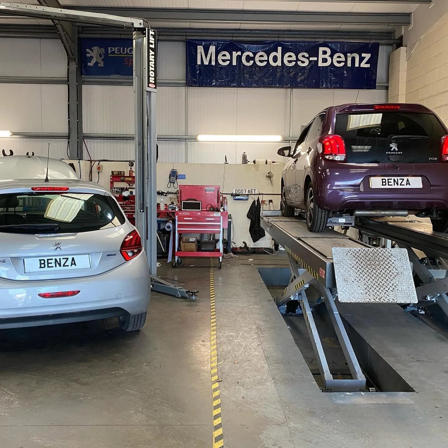 Two Peugeot cars being serviced at Benza Autos workshop in Birkenhead