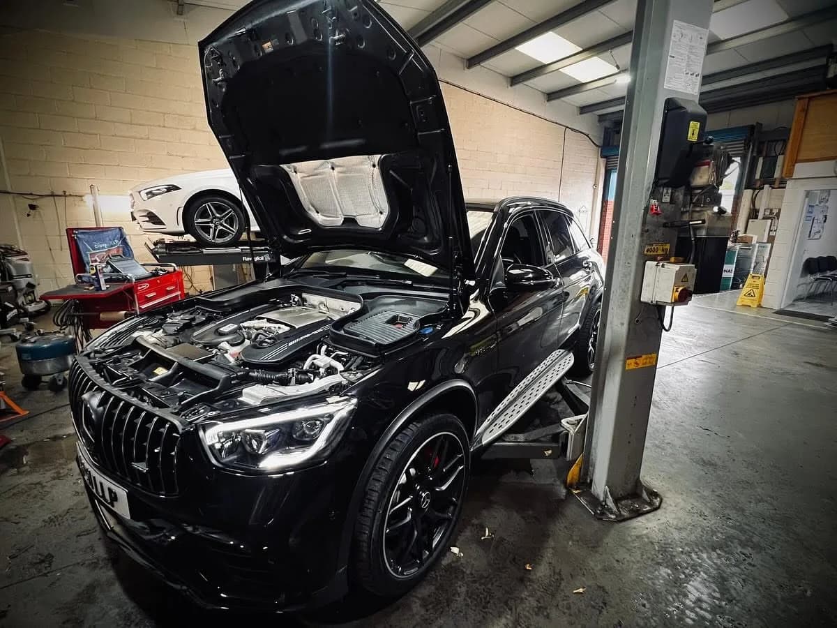 Mercedes-Benz SUV on a ramp with bonnet open for servicing at Benza Autos